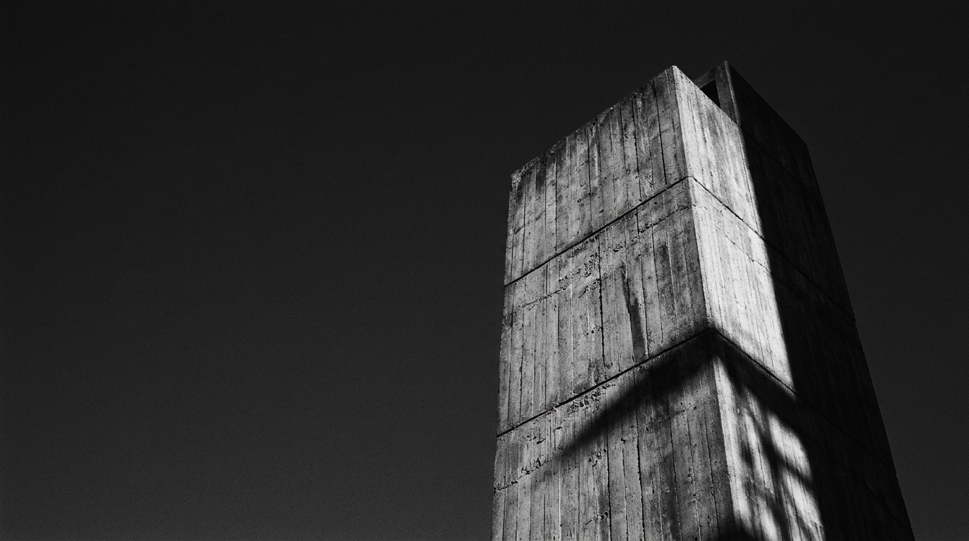A dark monolithic board-formed concrete tower rising against a near-black sky.